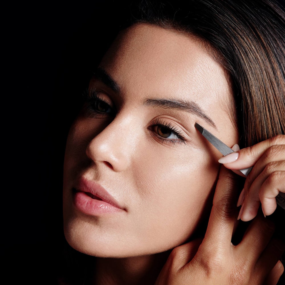 Image of model using precision tweezers to pluck stray hairs