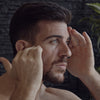 Image of male model examining his face