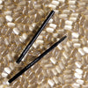 Image of the tip of Hi-Def Brow Pencil laying on a background of the same dark brown color